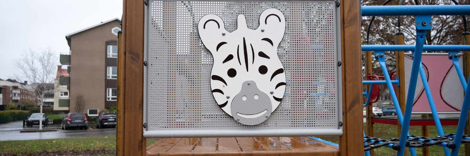 Un panel de cabeza en forma de cebra en un lateral de una unidad de parque infantil.